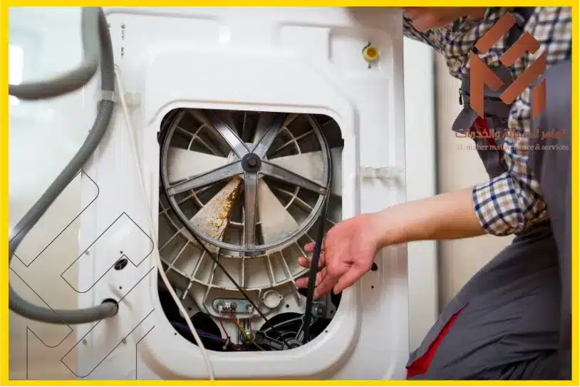 صيانة غسالة دايو بمكةمن الخلف مع ظهور يدي فني.