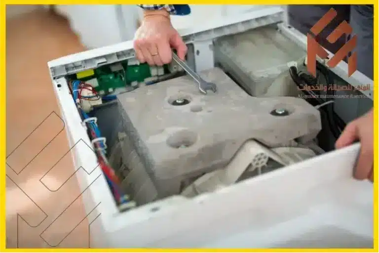 صيانة غسالات اتوماتيك مكة مفتوحة يتم إصلاحها باستخدام مفتاح ربط.