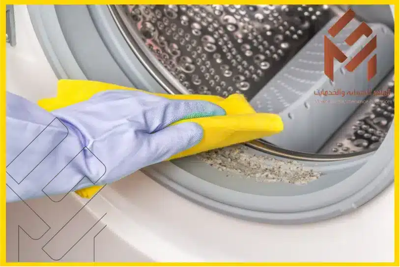 يد للبس قلفز مع قطعة قماش صفراء يقوم بتنظيف تنظيف الفلتر وجلدة الباب في صيانة غسالة دايو بمكة