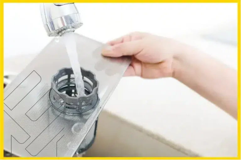 شخص يقوم بغسل فلتر غسالة الصحون تحت الماء من الصنبور، توجيهات ونصائح لصيانة غسالة الصحون وتصحيح الأخطاء الشائعة.