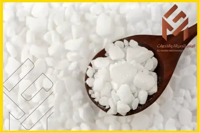 ملعقة خشبية تحمل كمية ملح غسالة الصحون