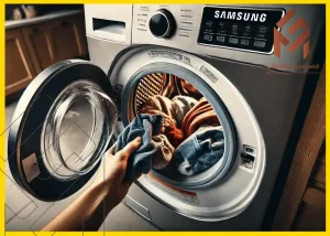 غسالة سامسونج مفتوحة مع ملابس ملونة بالداخل في غرفة الغسيل، يد تقوم بإضافة قطعة قماش زرقاء، تعكس موضوع صيانة وتصليح أجهزة سامسونج.