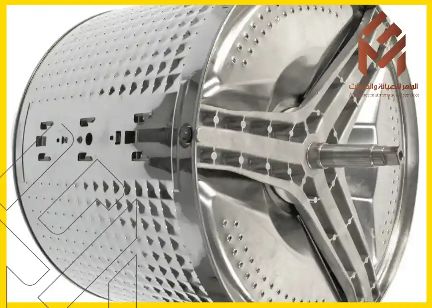 أسطوانة معدنية لغسالة أوتوماتيكية على خلفية بيضاء. الغسالة تقفز أثناء الدوران.