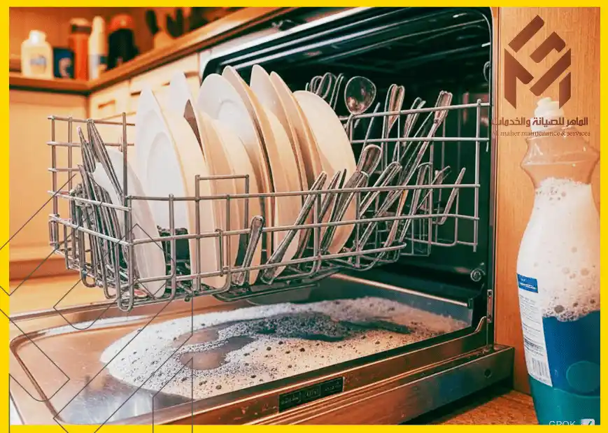 غسالة أطباق مفتوحة تحتوي على أطباق وأواني، مع آثار مسحوق تنظيف في الأسفل، والزجاجة على الجانب الأيمن يظهر عليها رغوة. استخدام صابون الأطباق العادي