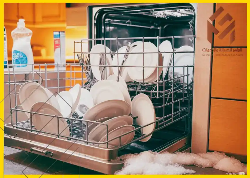غسالة صحون مليئة بالأطباق والصابون على الأرض.استخدام صابون الأطباق العادي