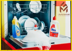 غسالة أطباق مفتوحة تفيض بالصابون مع زجاجتين مناستخدام صابون الأطباق العادي، واحدة في المقدمة وأخرى بجانبها.