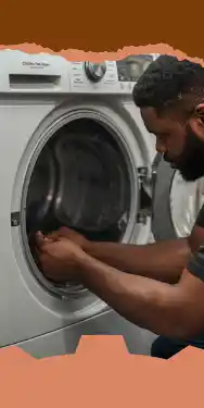 رجل يجلس أمام صيانة المجففات ويفتح بابها لوضع أو إخراج الغسيل.