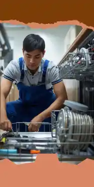 شخص يرتدي زي عمل أزرق يركب ويعمل صيانة غسالات الصحون في مطبخ.